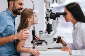 A young girl at the optometrist getting her eyes examined for myopia