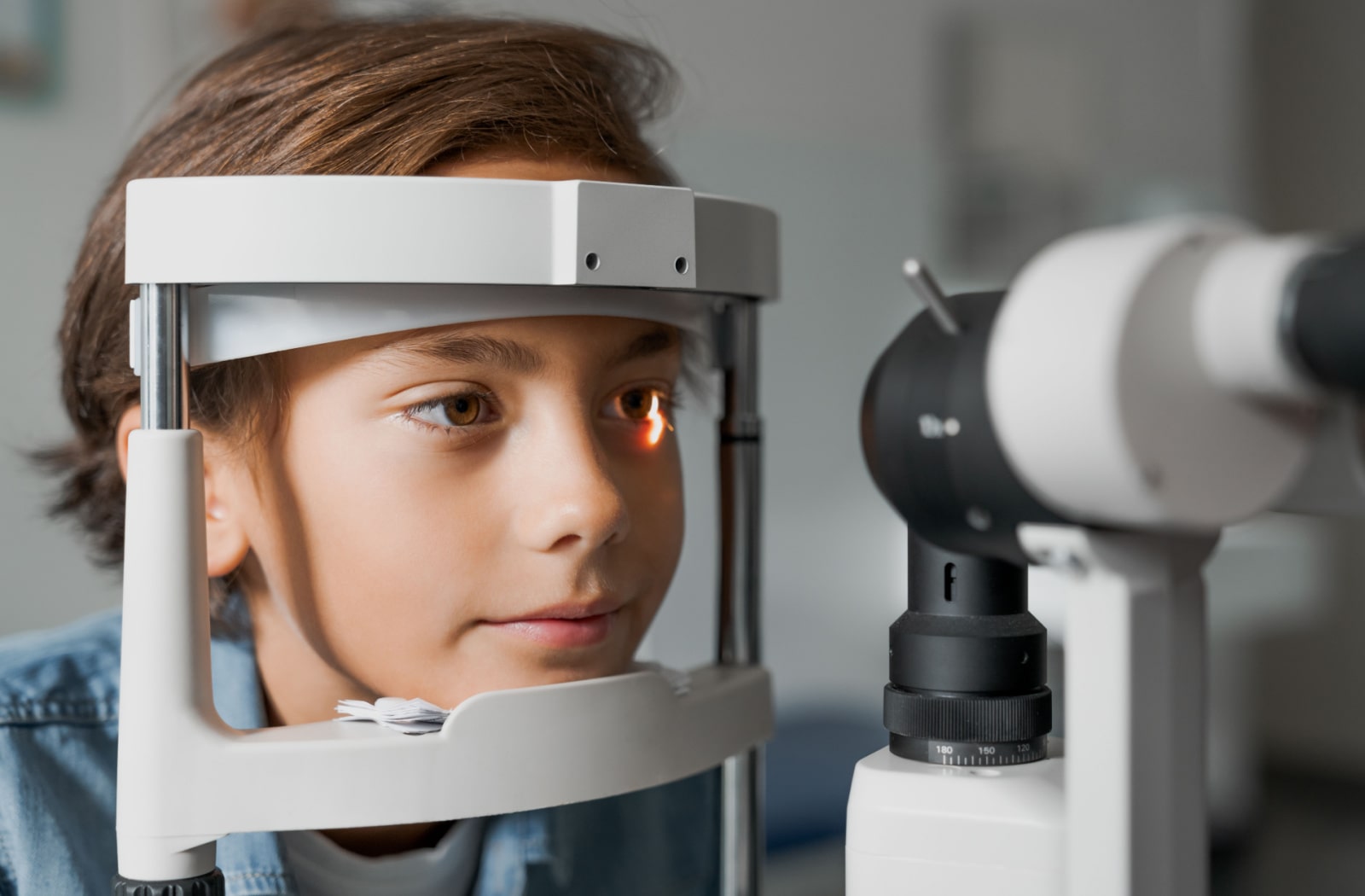 A child undergoing an eye health assessment at his optometrist's office