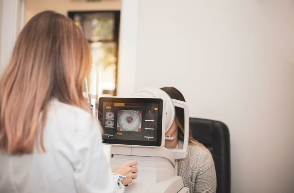 A female optometrist using corneal topography to examine a patient's eye for astigmatism.