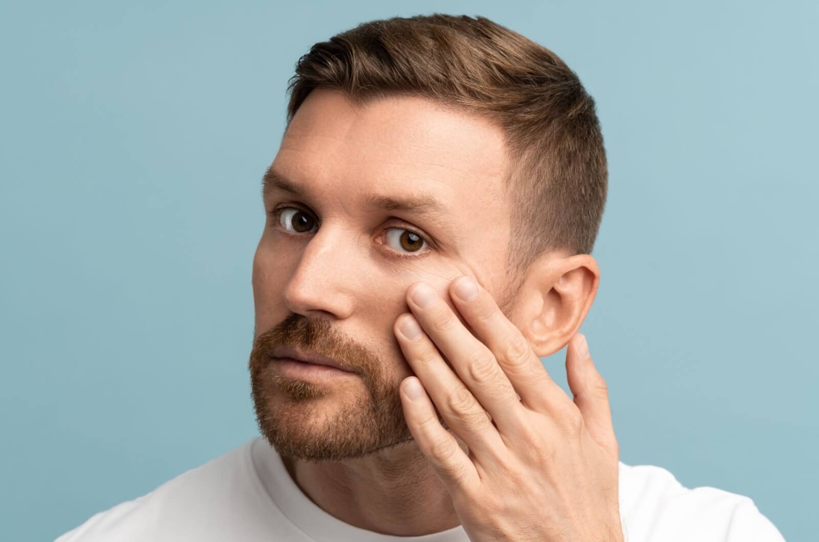 A person examining their sunken in eyes.