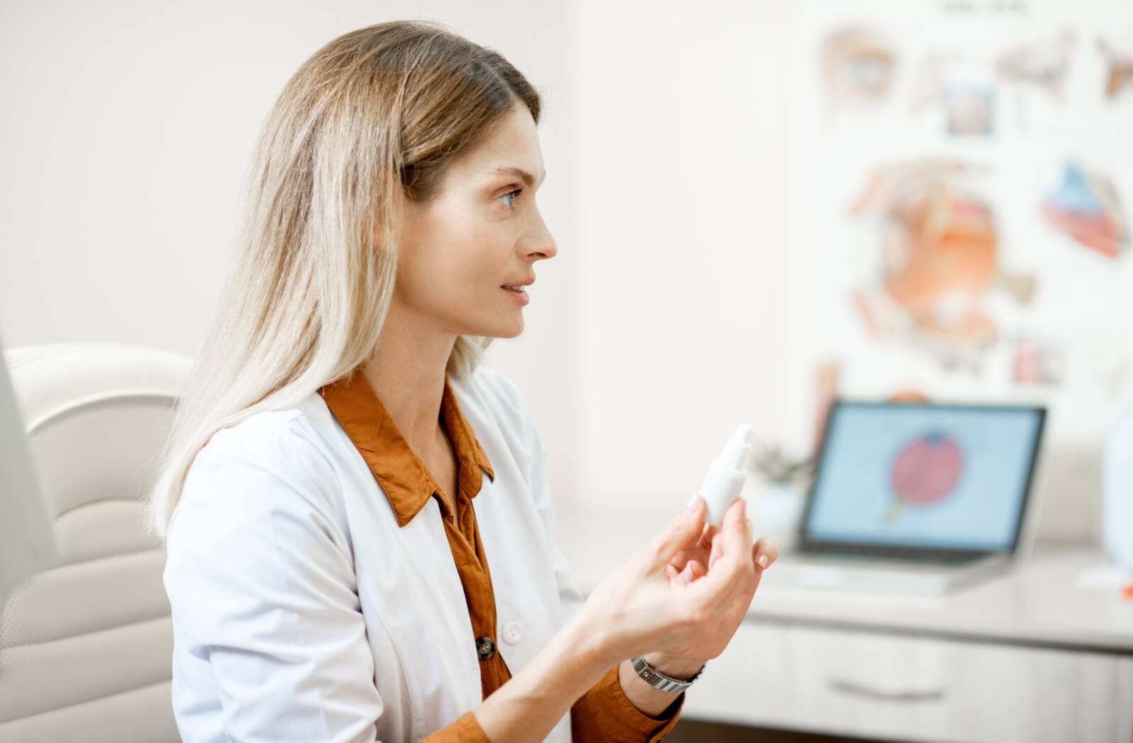 An optometrist holding a bottle of atropine eye drops for myopia explaining how to safely use them.