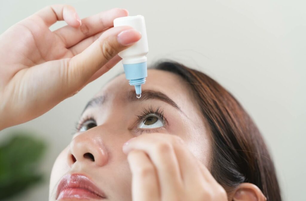 Close-up of a woman applying prescription eye drops to relieve dry eye symptoms.