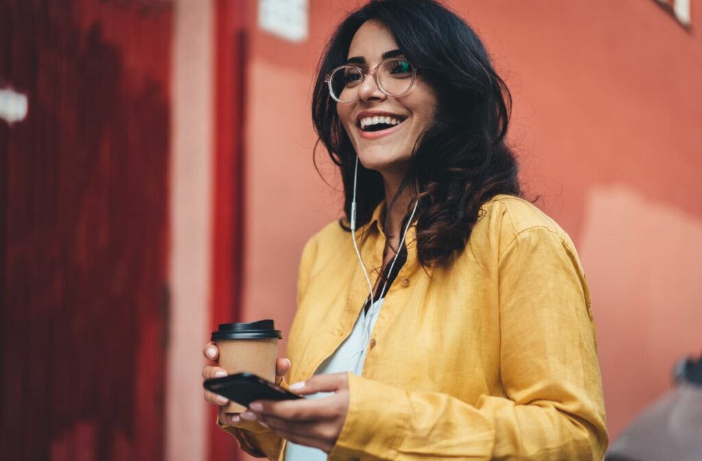 A young professional wearing stylish sunglasses checks their phone.