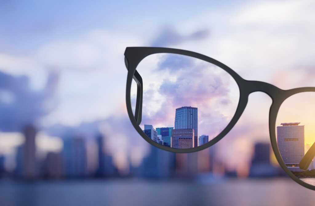 City skyline in focus through eyeglass lenses with blurred background.