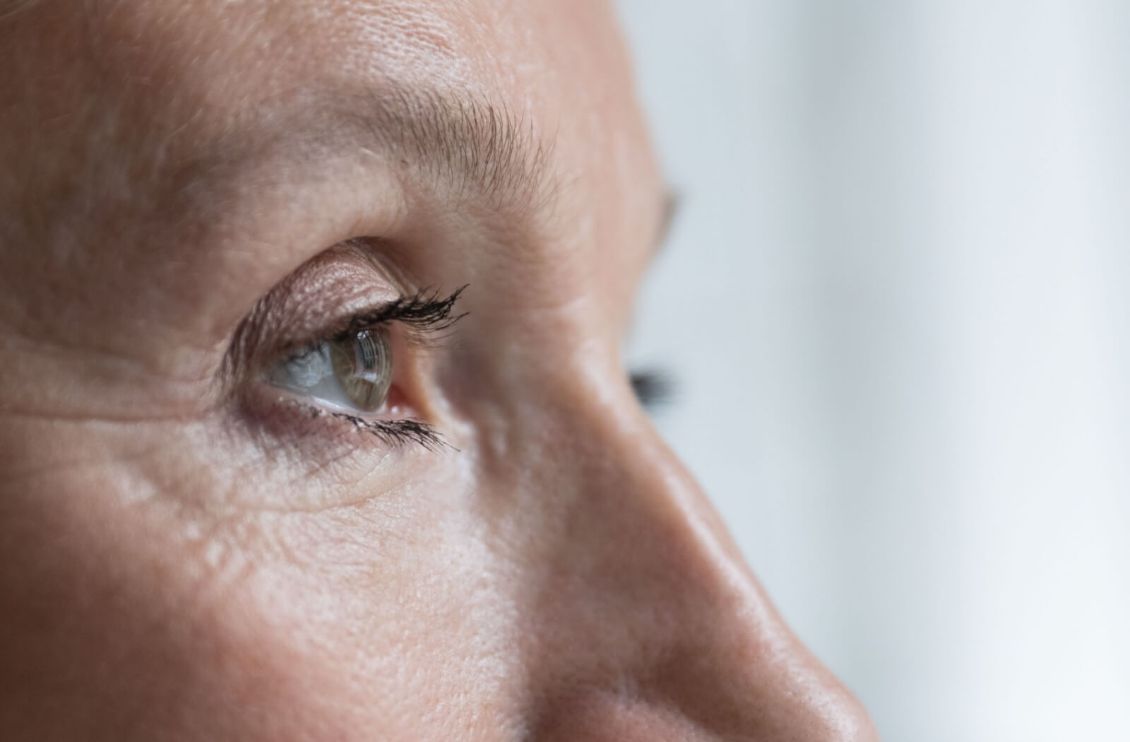 A close-up side profile of a person’s eye, used to illustrate a guide on the genetic risks and hereditary factors of macular degeneration.